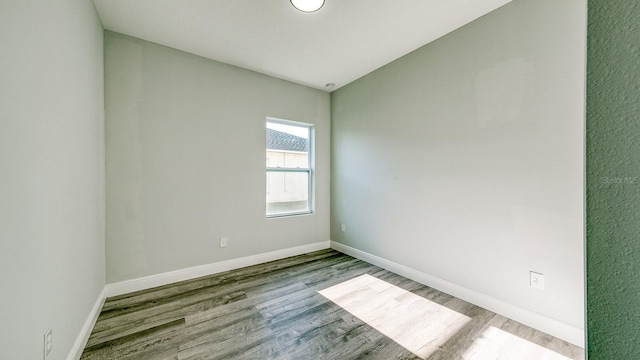 empty room with baseboards and wood finished floors