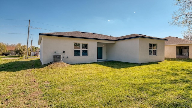 back of house featuring a yard, a shingled roof, central AC, and stucco siding