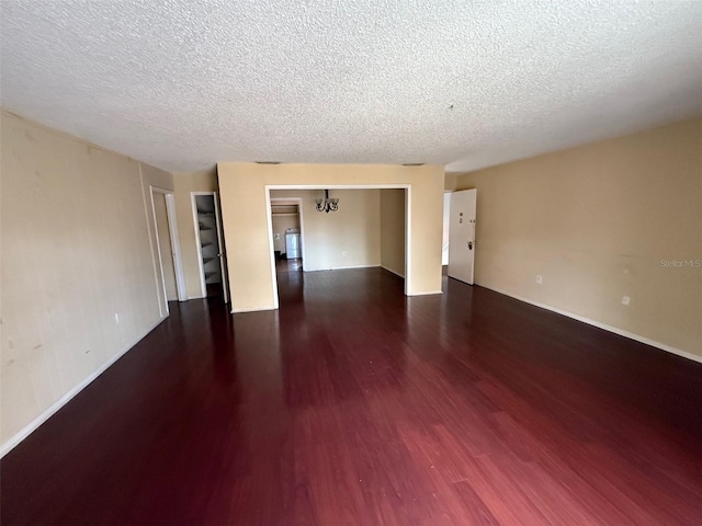 empty room featuring a textured ceiling and wood finished floors