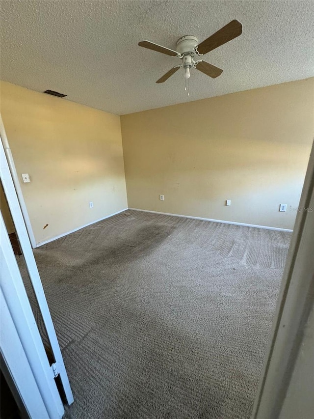 unfurnished room featuring ceiling fan, a textured ceiling, visible vents, and carpet flooring