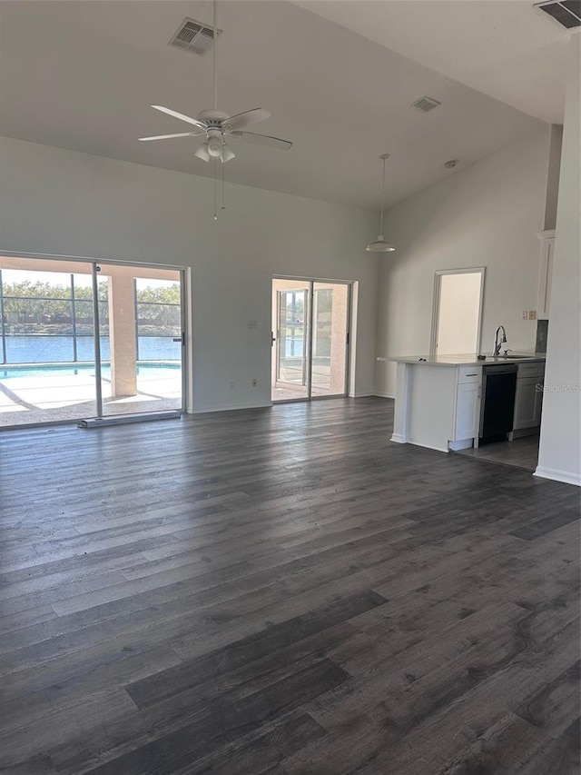 unfurnished living room with visible vents, dark wood-style floors, ceiling fan, high vaulted ceiling, and a sink