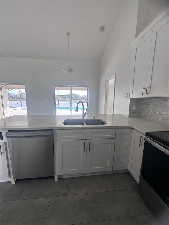 kitchen with appliances with stainless steel finishes, tile patterned flooring, a sink, and a healthy amount of sunlight