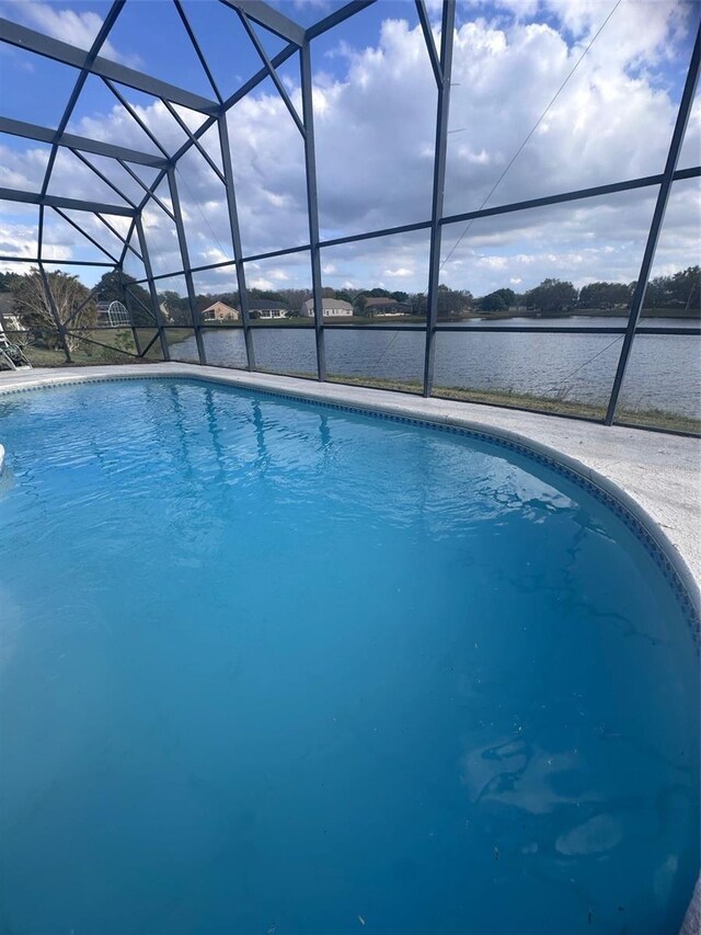 outdoor pool with glass enclosure and a water view