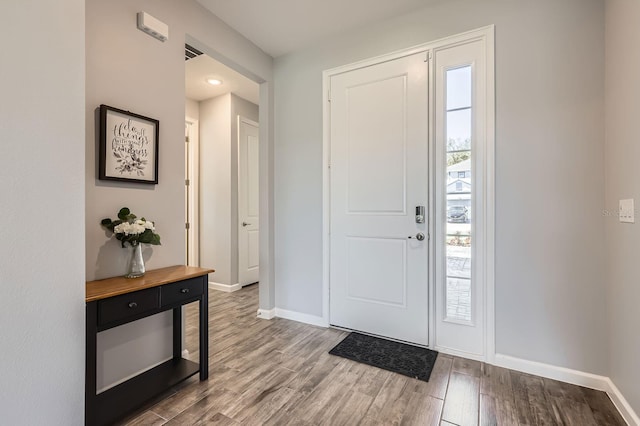 foyer with plenty of natural light, wood finished floors, and baseboards