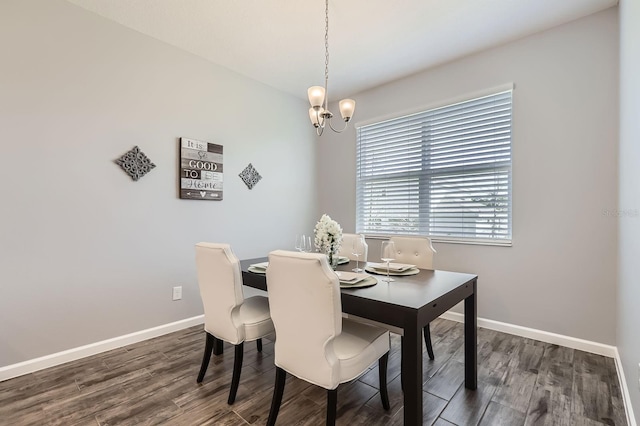 dining area featuring a chandelier, wood finished floors, and baseboards