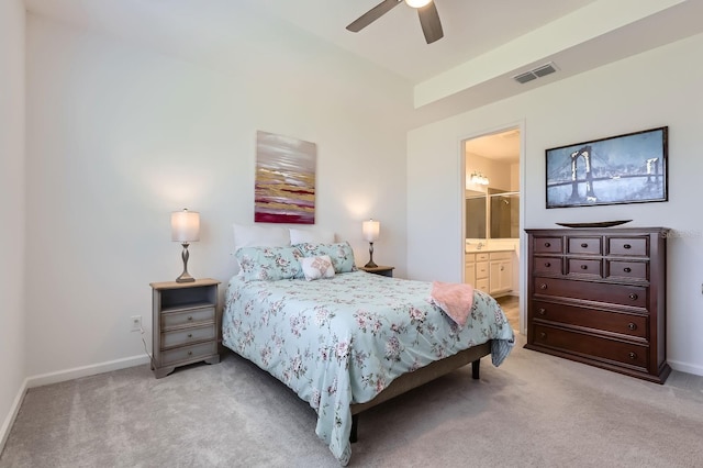 bedroom with light colored carpet, ensuite bath, visible vents, and baseboards