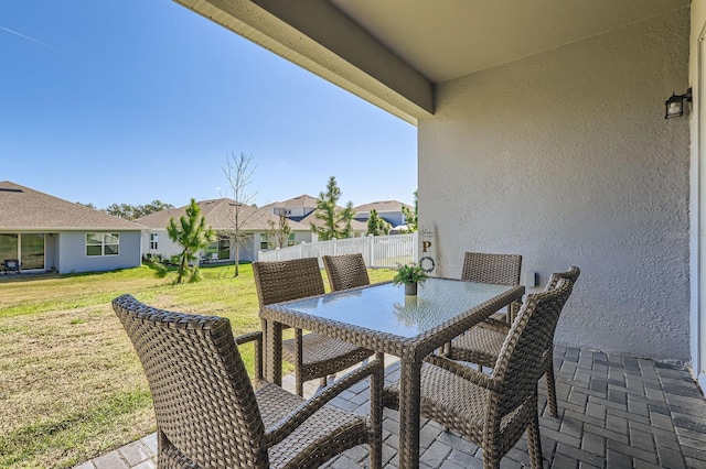 view of patio featuring outdoor dining area and fence