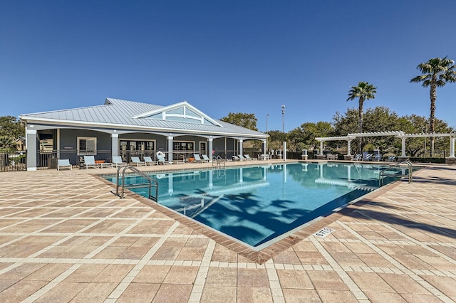 community pool with a patio area, fence, and a pergola