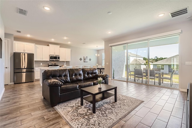 living area featuring recessed lighting, visible vents, and wood finished floors