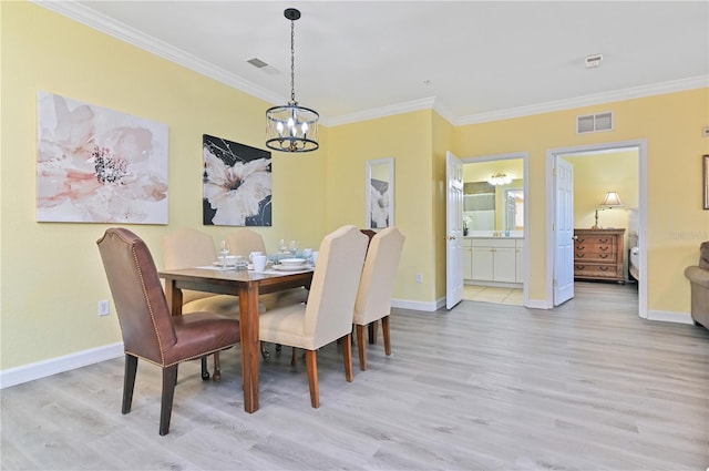 dining space with light wood finished floors, ornamental molding, visible vents, and baseboards