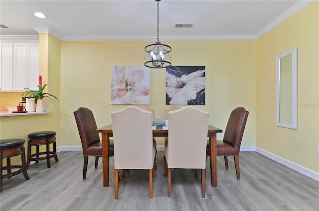 dining area with ornamental molding, baseboards, visible vents, and light wood finished floors