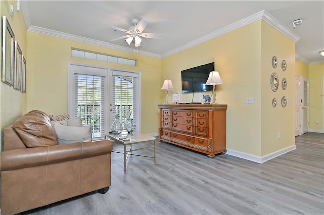 sitting room with french doors, ornamental molding, a ceiling fan, wood finished floors, and baseboards