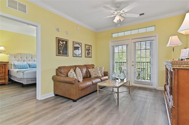 living area featuring baseboards, ornamental molding, visible vents, and light wood-style floors