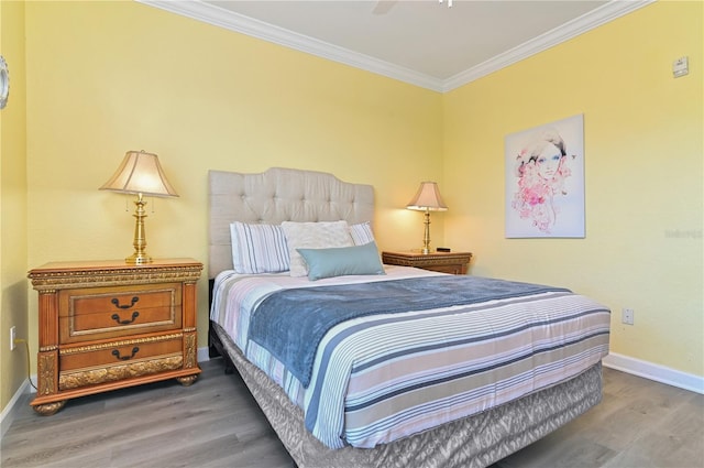 bedroom featuring a ceiling fan, baseboards, crown molding, and wood finished floors