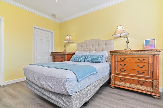 bedroom featuring baseboards, crown molding, and wood finished floors