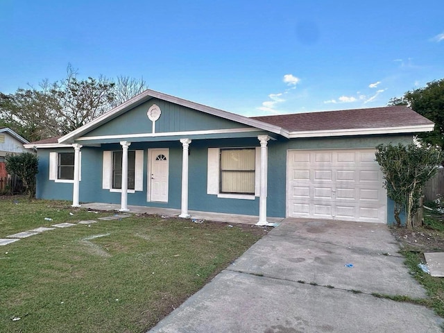 ranch-style home featuring a garage, a front yard, driveway, and stucco siding