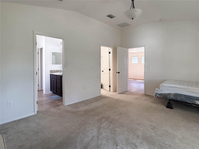 unfurnished bedroom featuring baseboards, visible vents, vaulted ceiling, and light colored carpet