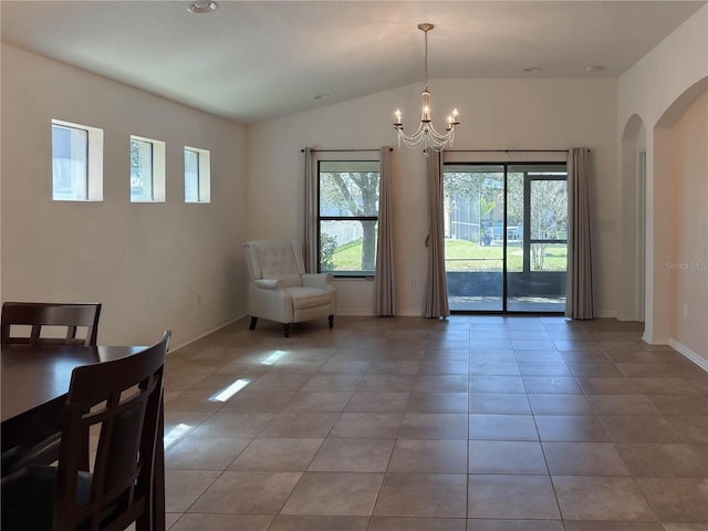 unfurnished dining area with a chandelier, plenty of natural light, arched walkways, and lofted ceiling