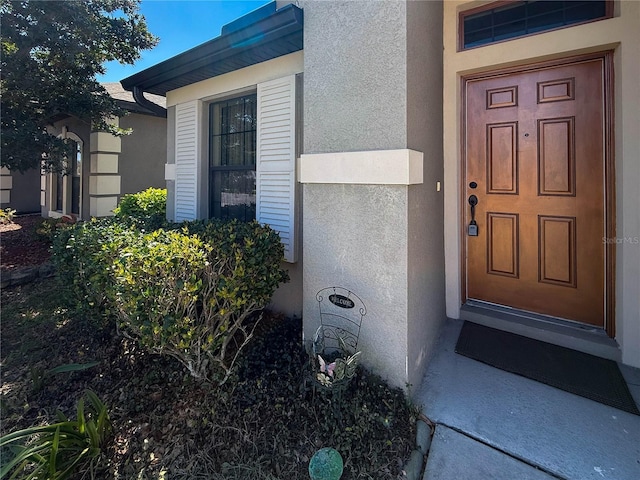 view of exterior entry featuring stucco siding