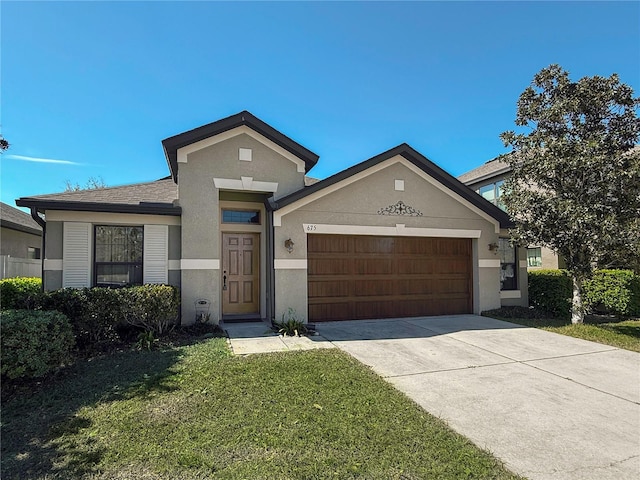 view of front of house with driveway, stucco siding, roof with shingles, an attached garage, and a front yard