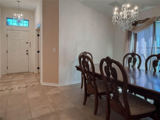 dining area featuring a notable chandelier, baseboards, and light tile patterned floors