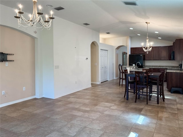 dining area with lofted ceiling, an inviting chandelier, baseboards, and visible vents