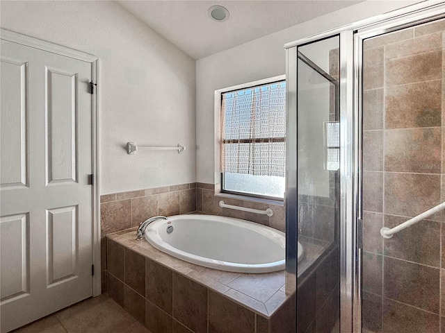 bathroom with tile patterned flooring, a shower stall, and a bath