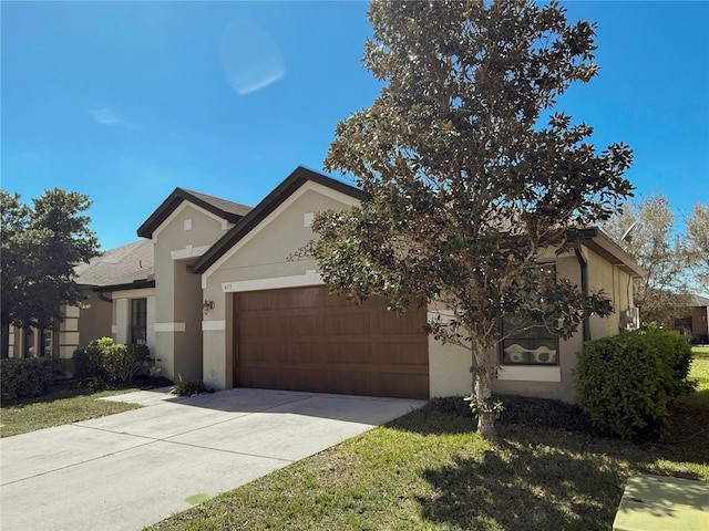 view of front facade featuring an attached garage, concrete driveway, and stucco siding