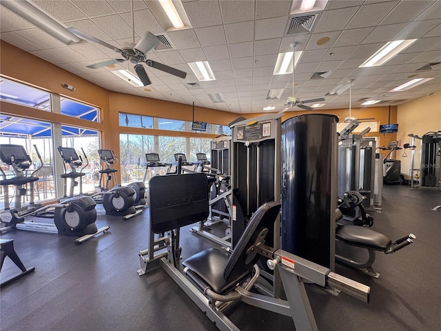 workout area featuring a paneled ceiling, ceiling fan, and visible vents