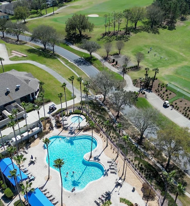 pool with view of golf course, a patio, and a hot tub