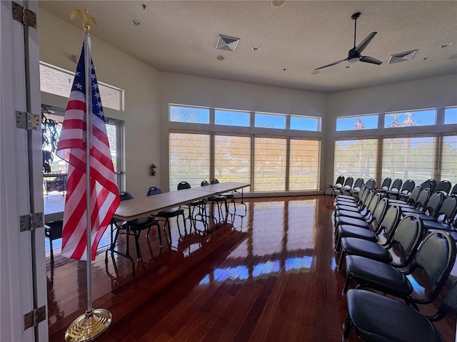 interior space with a wealth of natural light, visible vents, and wood finished floors