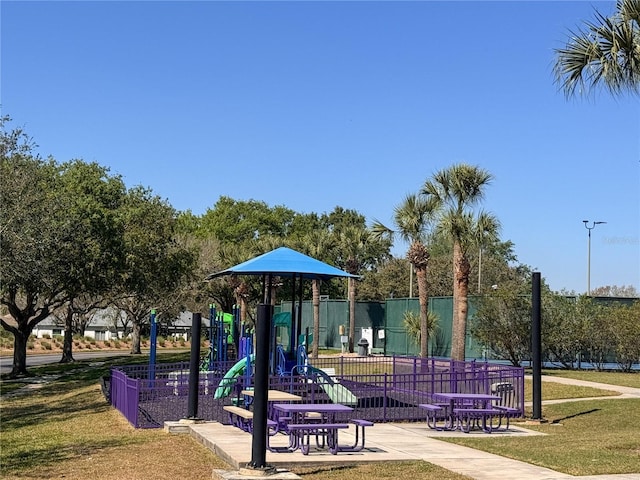 community jungle gym featuring a yard and fence