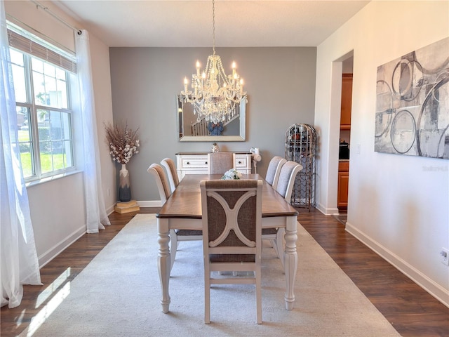 dining room with baseboards, a chandelier, and dark wood-type flooring