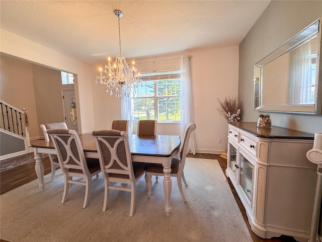 dining room with an inviting chandelier, baseboards, stairway, and a textured ceiling