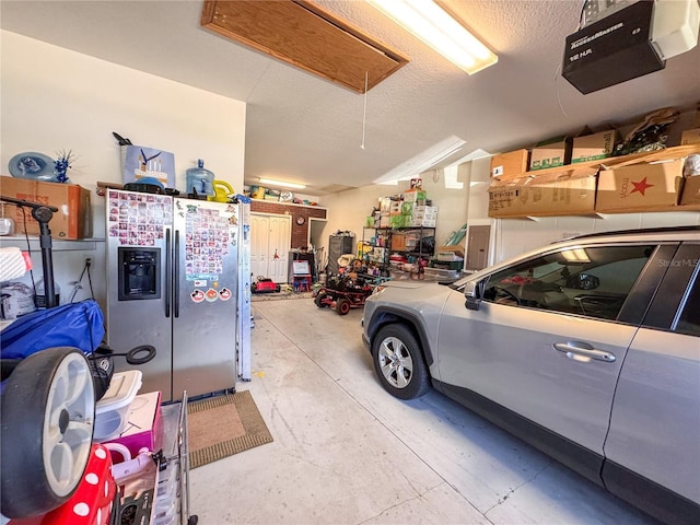 garage with a garage door opener and stainless steel fridge with ice dispenser