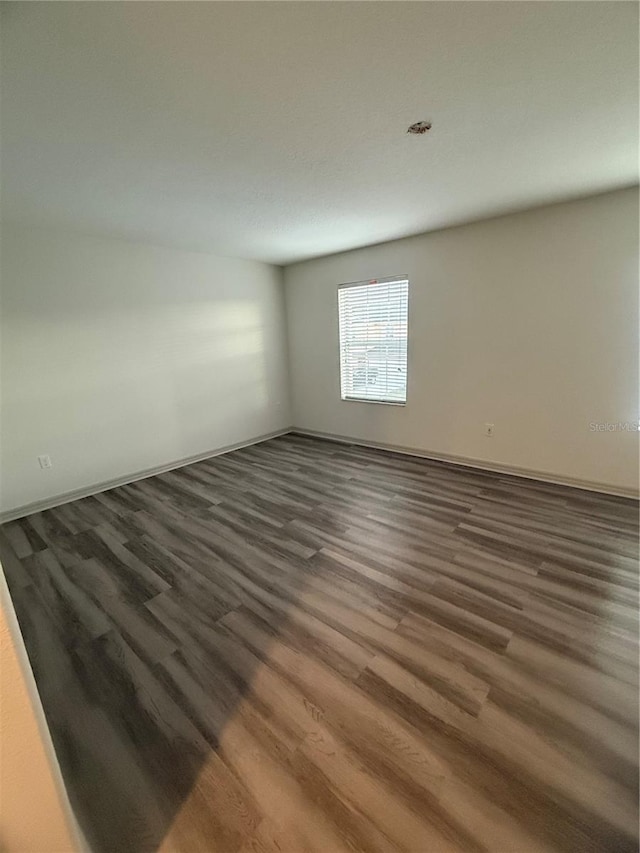 spare room featuring dark wood finished floors