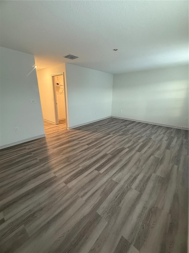 spare room featuring visible vents, a textured ceiling, and wood finished floors