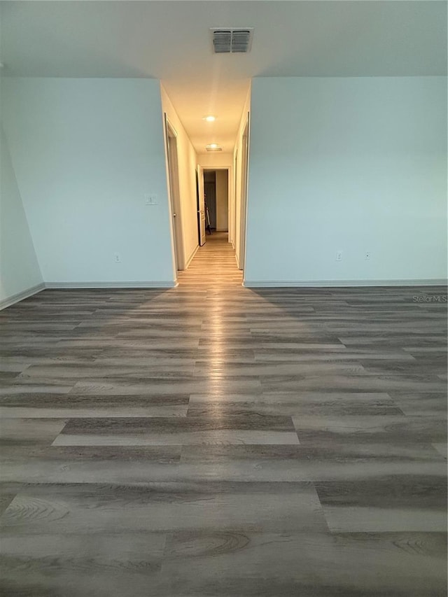 unfurnished room with wood finished floors, visible vents, and baseboards