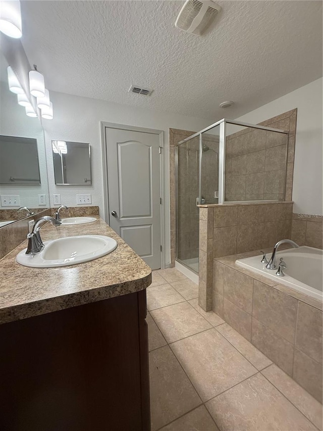 full bathroom with tile patterned flooring, a garden tub, a shower stall, and a sink