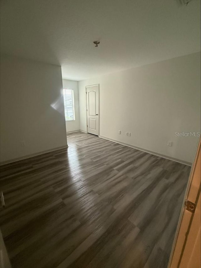 spare room featuring dark wood-style flooring