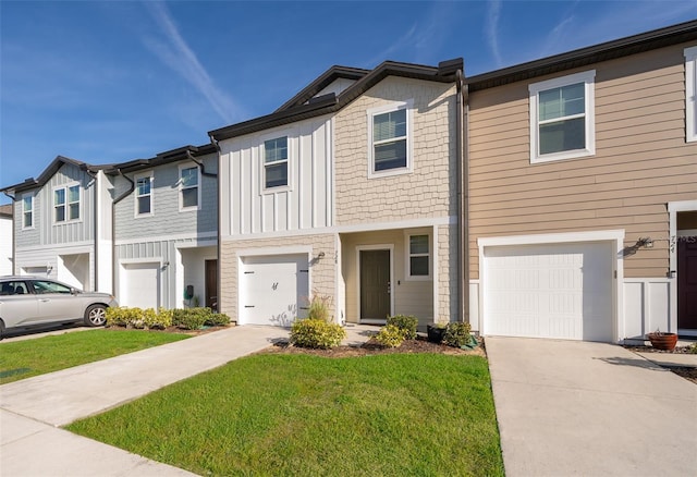 multi unit property featuring board and batten siding, concrete driveway, a front lawn, and a garage