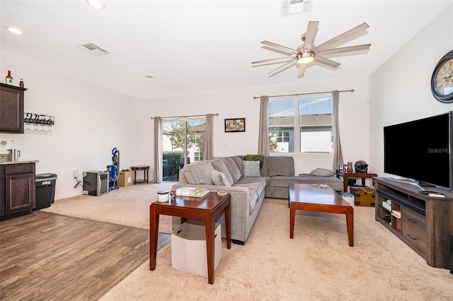 living room featuring light wood-style flooring, visible vents, ceiling fan, and recessed lighting