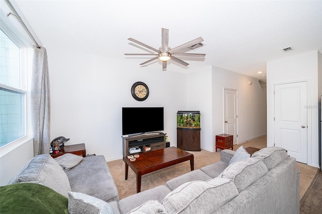 living room with a healthy amount of sunlight, light carpet, visible vents, and a ceiling fan