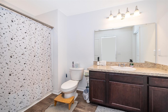 bathroom featuring curtained shower, toilet, wood finished floors, vanity, and baseboards