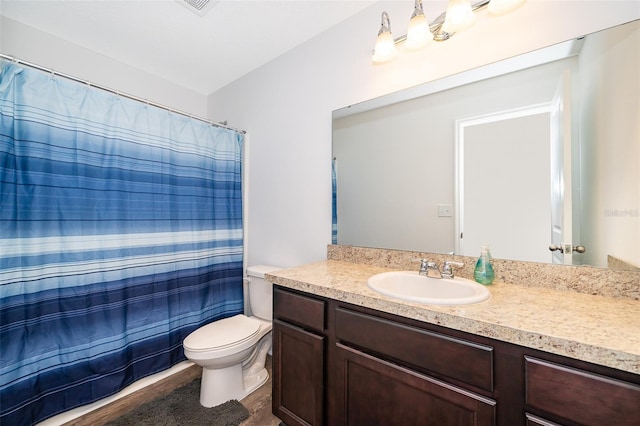 bathroom featuring toilet, a shower with shower curtain, and vanity