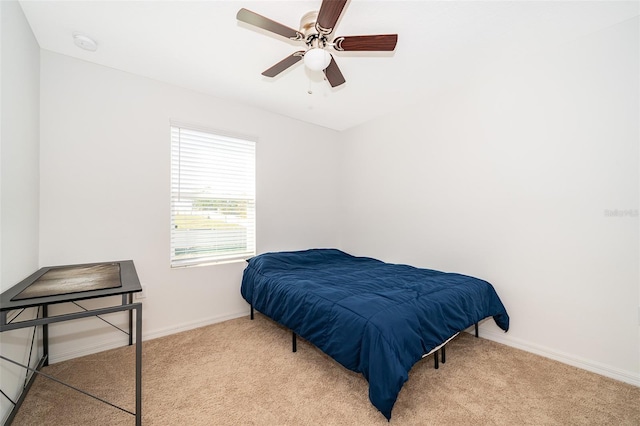 carpeted bedroom with ceiling fan and baseboards