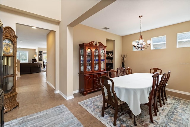 tiled dining room featuring baseboards, visible vents, and a chandelier