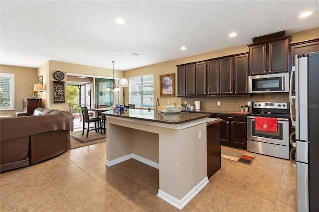 kitchen with stainless steel appliances, open floor plan, decorative backsplash, and dark brown cabinets