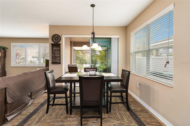 dining area featuring baseboards and an inviting chandelier