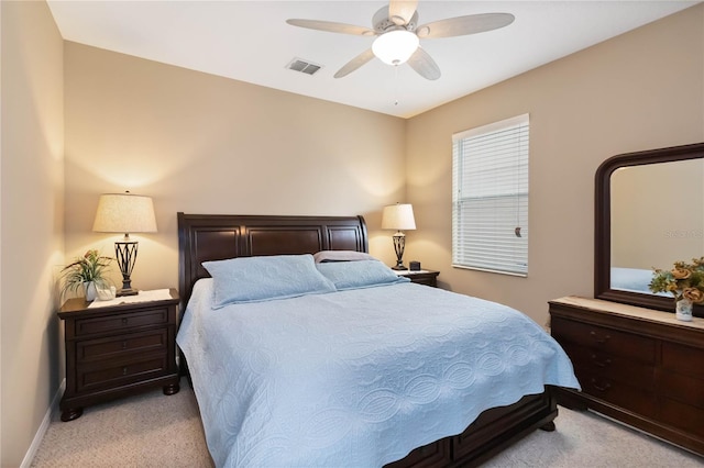 bedroom with a ceiling fan, light colored carpet, visible vents, and baseboards